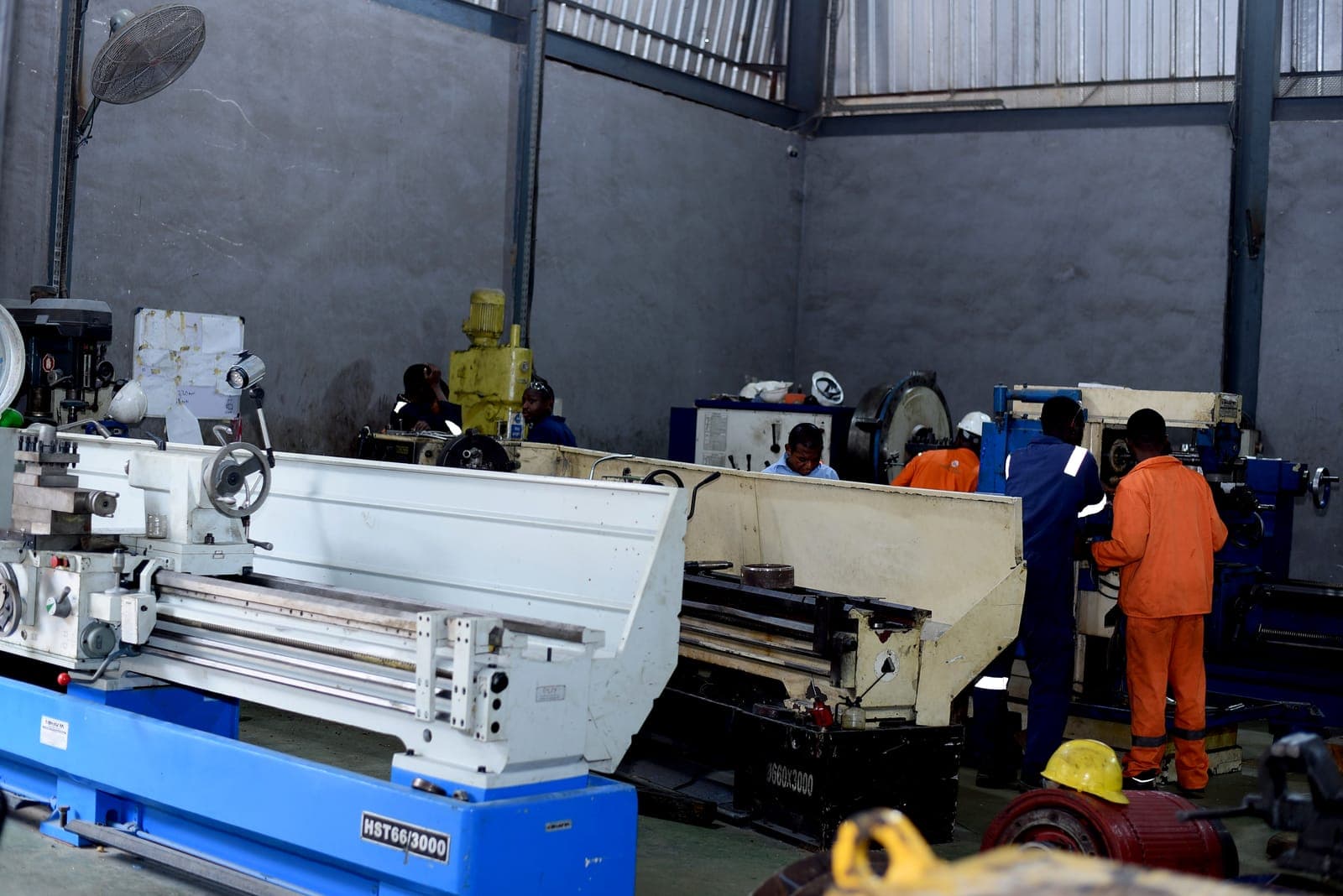 Technicians working alongside a lathe in the workshop