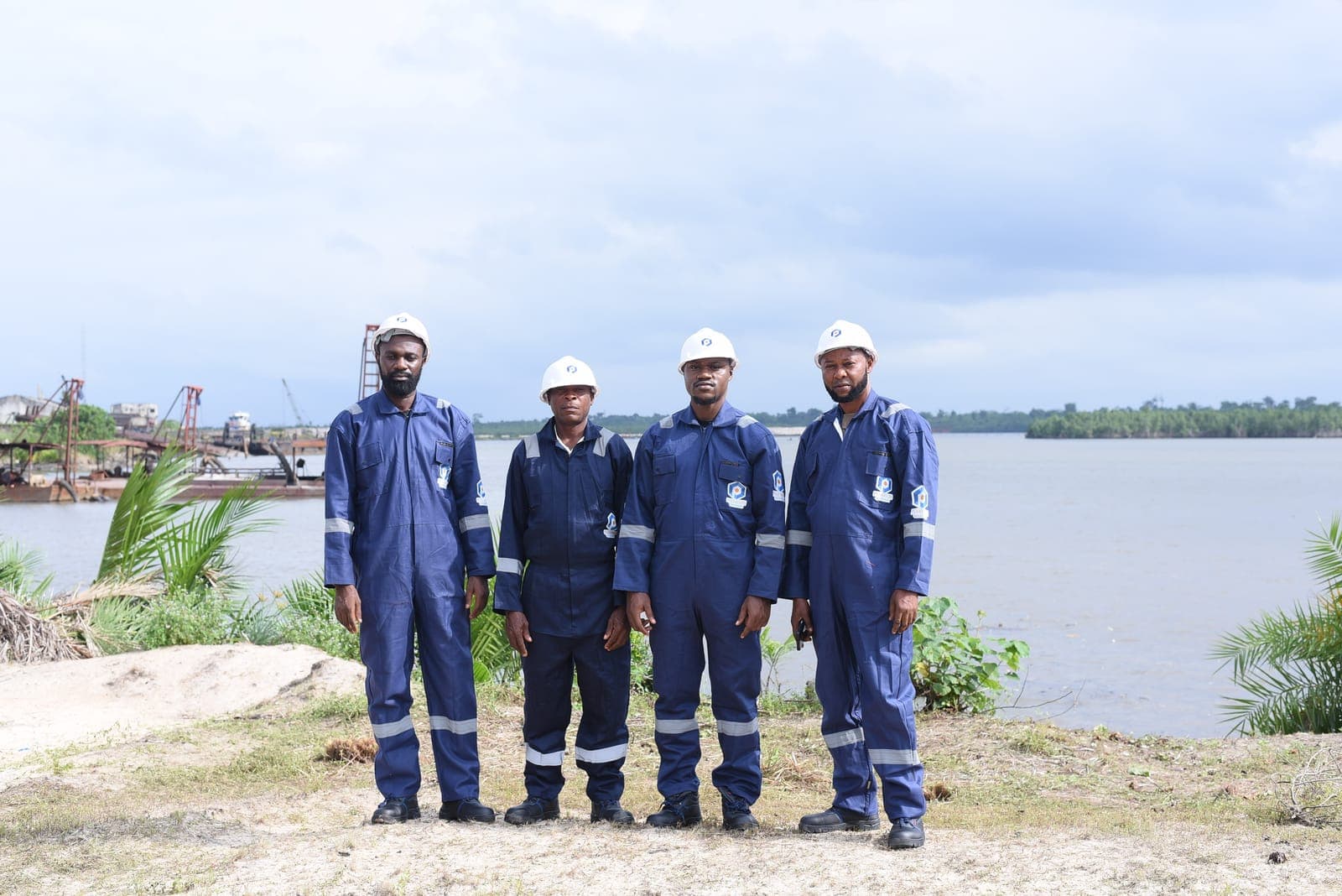 Peakware Offshore crew in coveralls and hard hats at the waterfront